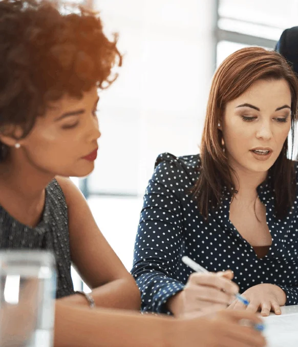 Two business partners review a bilingual agreement on a laptop with Instant Translation Services for clear legal wording.