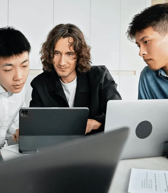 A team checks a timestamped meeting transcript on a laptop, showing Korean Transcription Services for business projects.