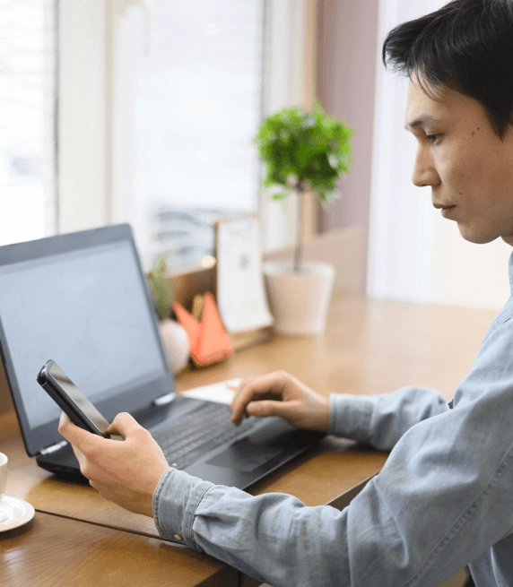 High-angle view of a man using a laptop for transcription services for recorded business calls to boost productivity. High-angle view of a man using a laptop for transcription services for recorded business calls to boost productivity.