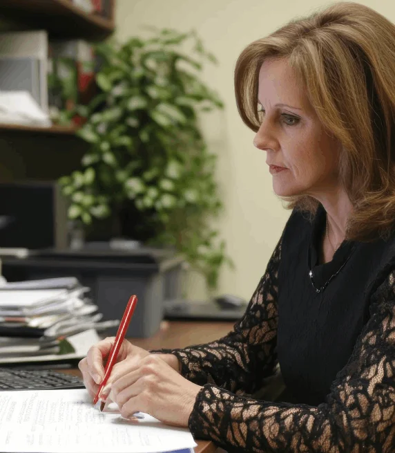 A manager reviews board meeting minutes transcribed with Irish Transcription Services, assigning actions and owners.