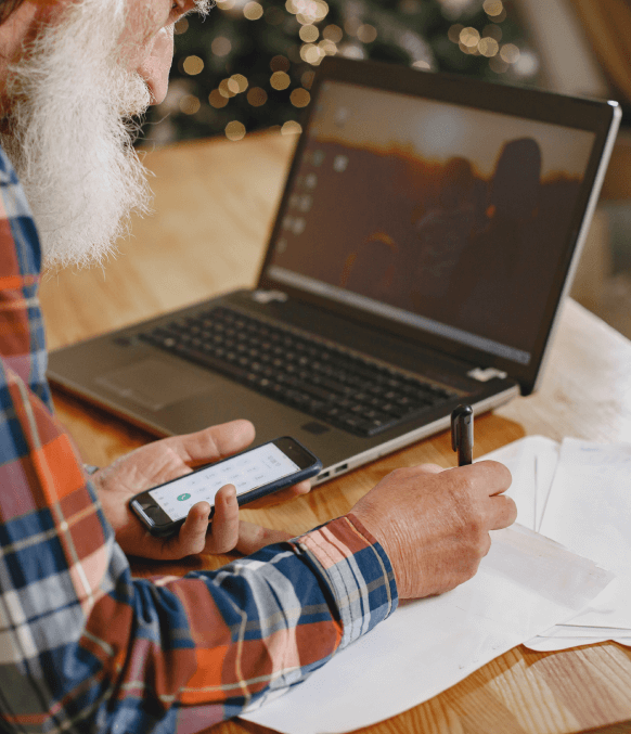 Expert man using a laptop and smartphone for emergency phone transcription services with fast turnaround times. Expert man using a laptop and smartphone for emergency phone transcription services with fast turnaround times.