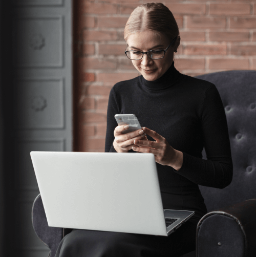 Woman using a laptop and smartphone for expert transcription services for documentation of telephone interviews. Woman using a laptop and smartphone for expert transcription services for documentation of telephone interviews.