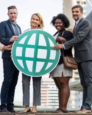 Diverse translation team holding a globe icon, symbolizing industry translation services for global business communication.
