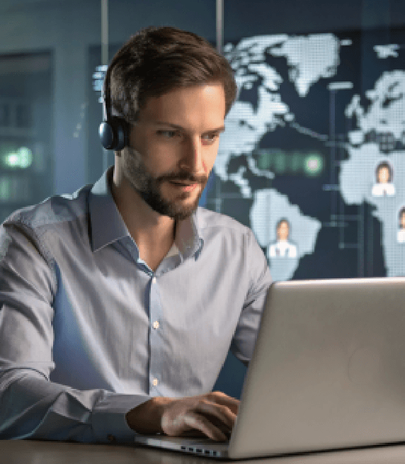 A technical support professional using a laptop for automated transcription services to bridge communication gap globally.