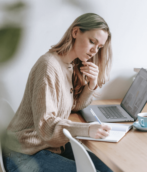 A professional audio transcriptionist preparing a written transcript on her notebook A professional audio transcriptionist preparing a written transcript on her notebook