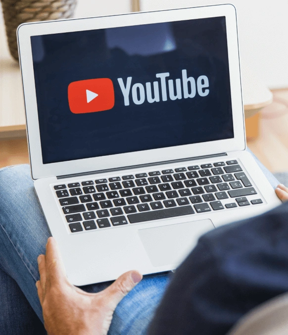Man sitting with an YouTube on laptop, highlighting YouTube video translation services for global audience reach. Man sitting with an YouTube on laptop, highlighting YouTube video translation services for global audience reach.