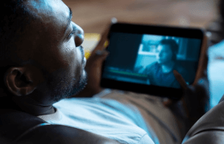   An man watching a video on his tablet 