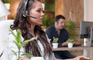  A Woman Transcriber with Headphones is Working on the Laptop
