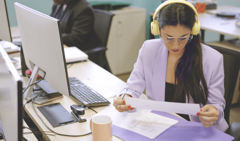 A focused woman reviews a financial report in a coworking space, symbolizing accurate transcription services in Baltimore.