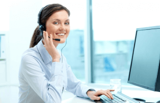  A person with earphones sitting in front of a computer