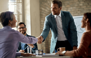  Business coworkers shaking hands during a meeting in the office focus is on a businessman