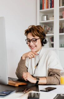 Cheerful woman in headphones using a computer