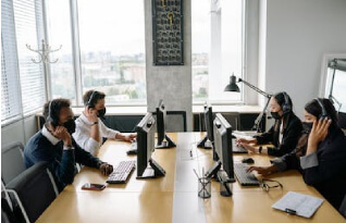 Men and women in an office set up with headpsets on