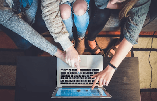 Three people pointing the hands of the laptop discussing something