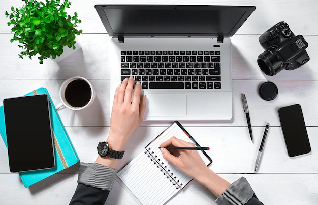 A professional transcriber working on laptop and taking notes for best work in Olathe.
