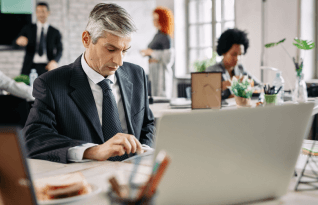 Expert analyzing documents in an office for Scalable plano transcription services ensure secure document handling.