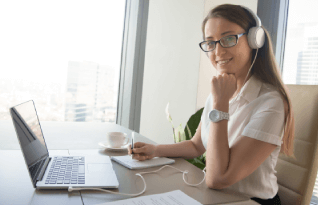 A woman works on a laptop for secure delivery options and technical features enhance Plano transcription service efficiency.