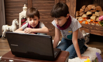 Two kids watching a cartoon movie with subtitles