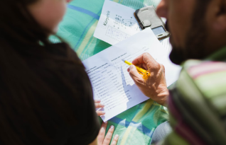  Two people learning from worksheets in two languages