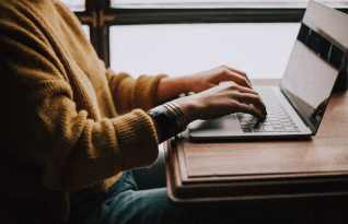 A picture of a woman typing on her laptop