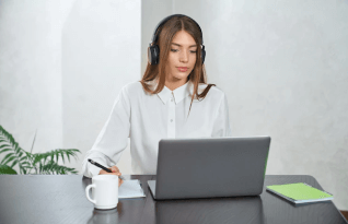 Woman in headphones using laptop at home