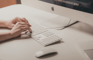  A picture of a woman's hands as she types on a keyboard