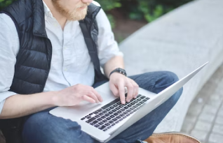 Transcriber working outdoors on a laptop 